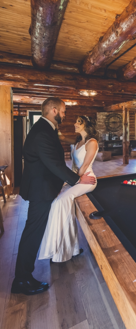 Bride and Groom on pool table in Log Cabin